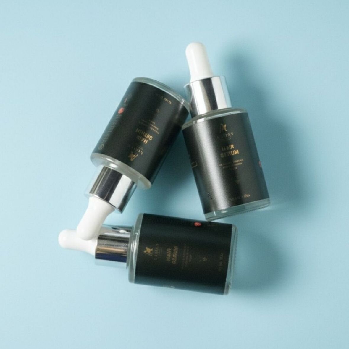 Aargo Lifestyle hair serum trio, matte black glass bottles with gold foil detailing